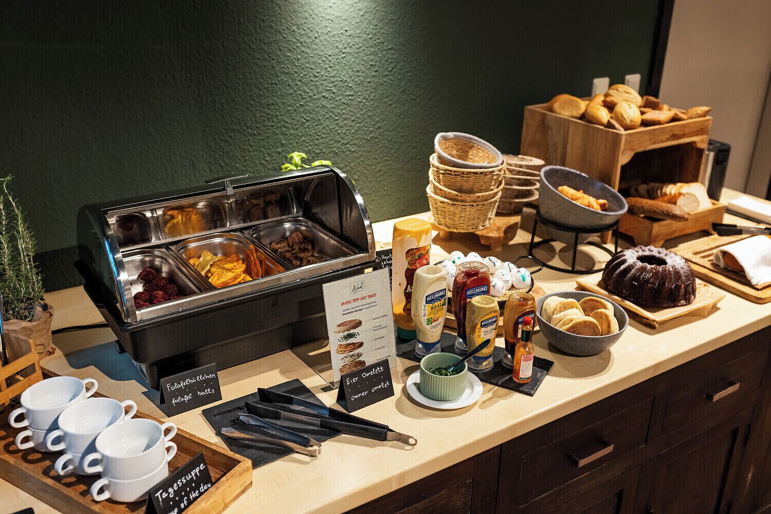 A buffet setup with various food items and condiments.