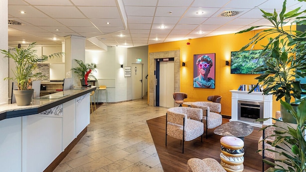 A hotel lobby with a reception desk, seating area, and a fireplace. - ACHAT Hotel Darmstadt Griesheim (Griesheim)