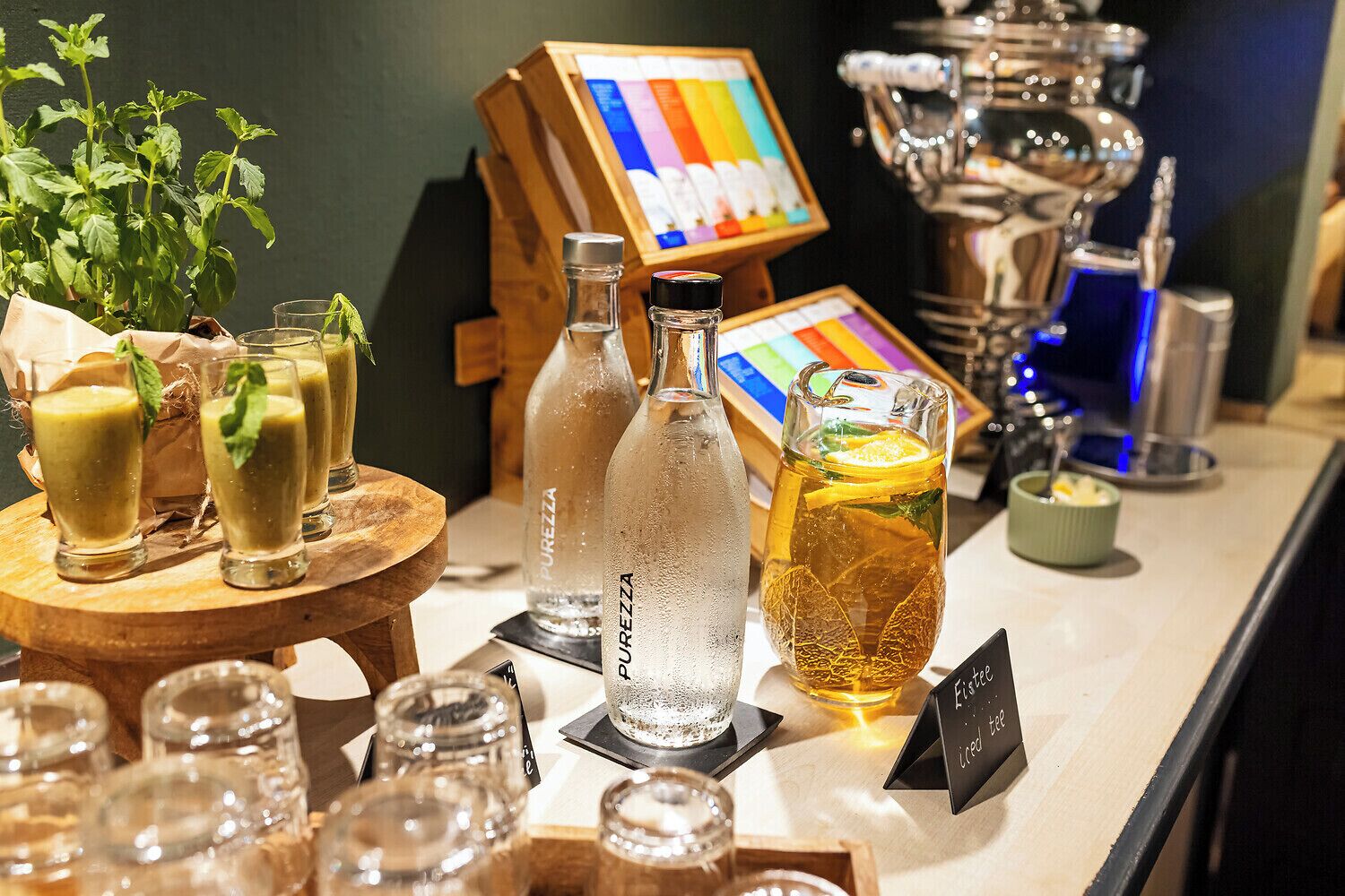 Angolo bar con diverse bevande, tra cui una caraffa, bottiglie e bicchieri.