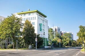 A hotel with a green and white facade, multiple floors, and a clear sky. - ACHAT Hotel Darmstadt Griesheim (Griesheim)