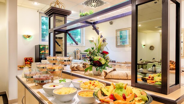 A buffet with various food items and a mirror reflecting the room. - ACHAT Hotel Frankenthal in der Pfalz (Frankenthal)