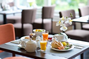 A breakfast table with a variety of food items, including eggs, toast, and fruit.