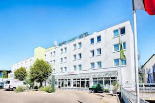 A hotel with a sign reading "ACHAT COMFORT HOTEL" and "Il Punto" below.