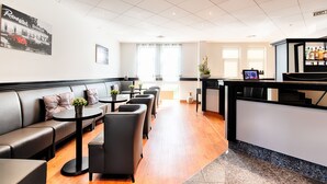 Un moderno vestíbulo de hotel con mostrador de recepción, zona de estar y un amplio ventanal.