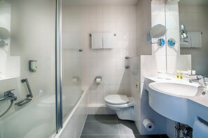 A modern bathroom with a glass shower enclosure, a toilet, and a sink with a mirror. - ACHAT Hotel Zwickau (Zwickau)