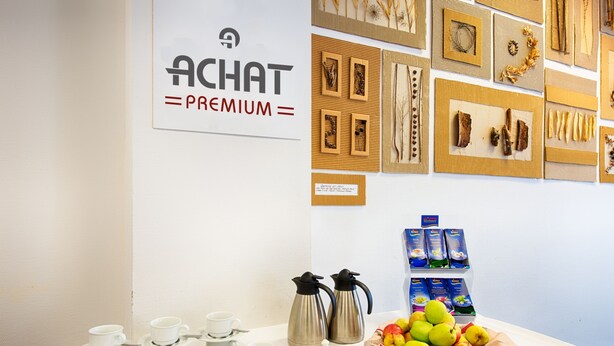 A table with white cups and saucers, two coffee makers, and a basket of apples. - ACHAT Hotel Zwickau (Zwickau)