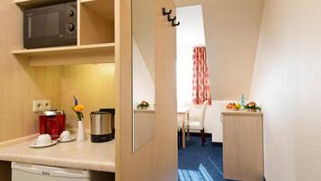 A compact kitchenette with a microwave, coffee maker, and a small sink.