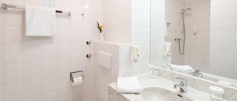 Un baño moderno con inodoro, lavabo y ducha.