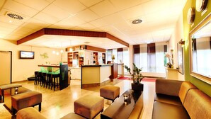 A hotel lobby with seating areas, a reception desk, and a bar. - ACHAT Hotel Chemnitz (Chemnitz)