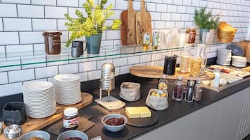 Montaje de bufé con diferentes alimentos, salsas y utensilios para servir.