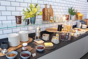 A buffet setup with various food items, condiments, and serving utensils. - ACHAT Hotel Schwetzingen Heidelberg (Schwetzingen)