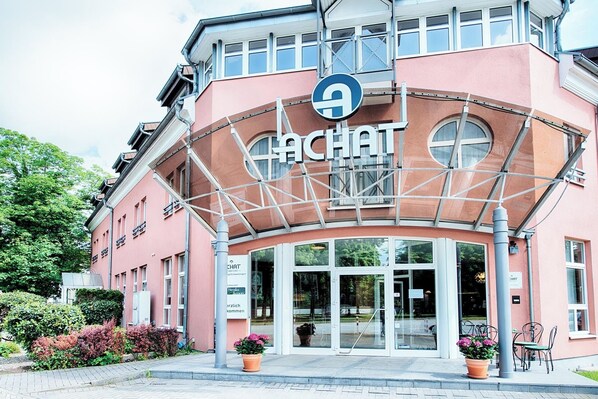 Un edificio con un letrero que dice "CHAT" y una señal circular azul con una 'A' blanca.