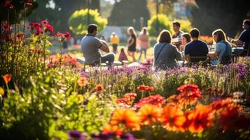 Un grupo de personas sentadas al aire libre en un jardín lleno de flores.