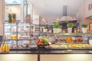 A buffet with various fruits, vegetables, and beverages.