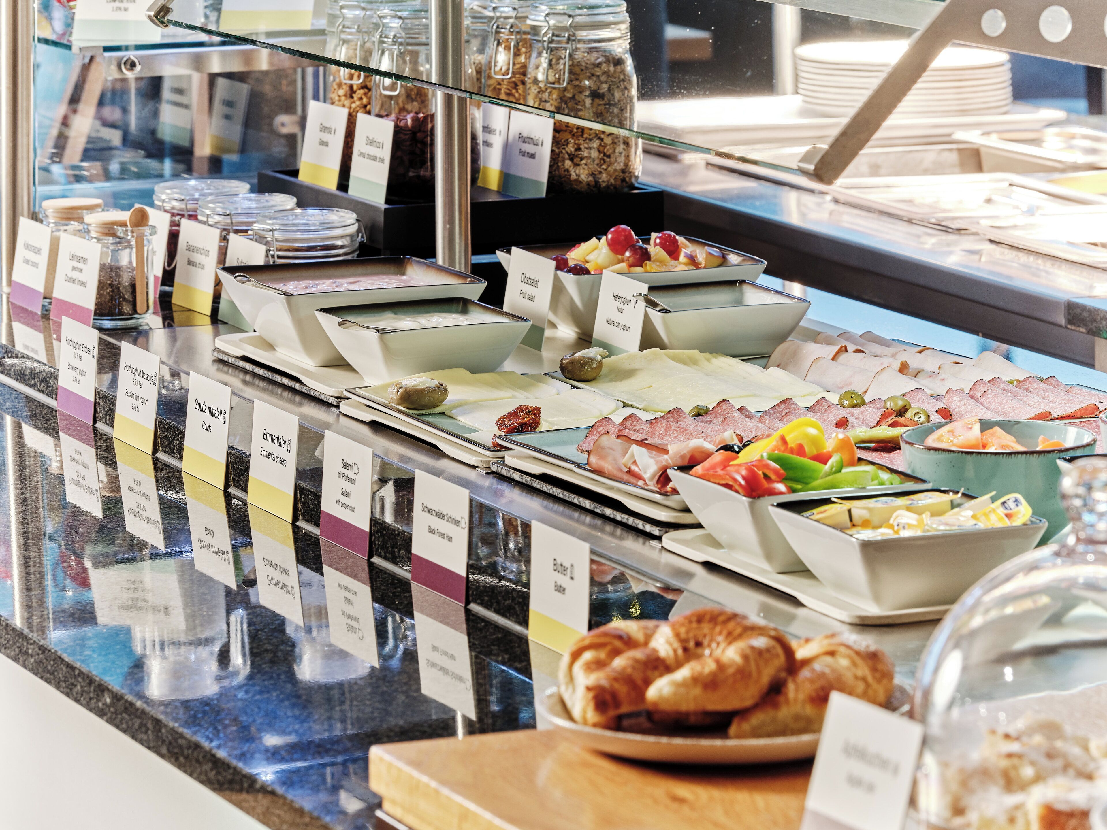 Ein Buffet mit verschiedenen Speisen und Beschriftungen.