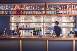 A bar with shelves of liquor bottles and glasses. - Garner Hotel Elmshorn by IHG (Elmshorn)