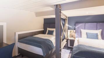 A hotel room with two beds, a desk, and a nightstand.