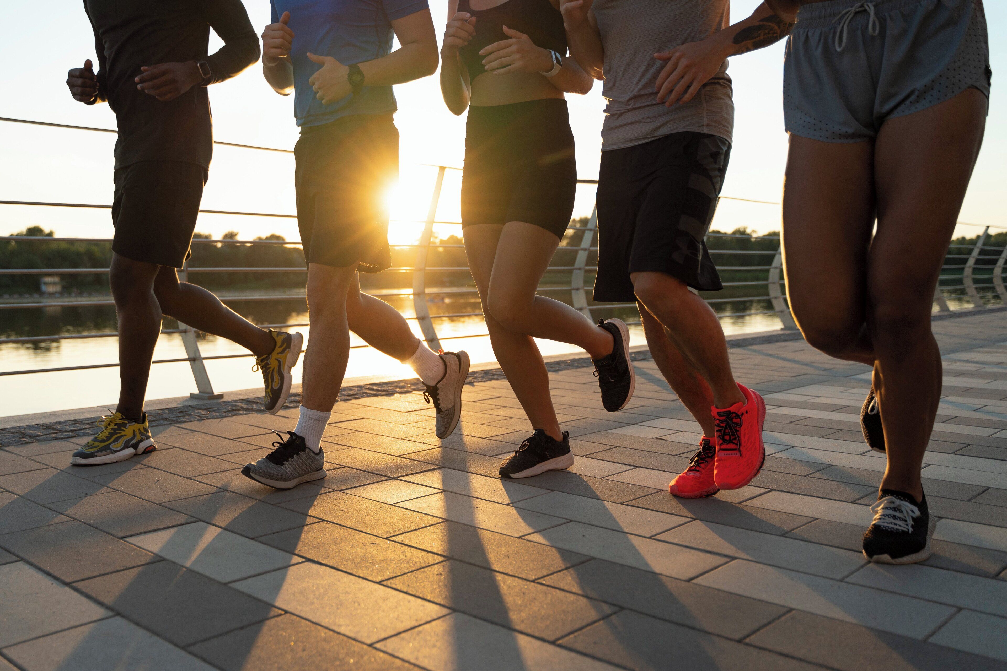 A group of people jogging on a tiled pathway.