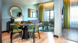A modern living room with a sofa, chairs, a dining table, and a large mirror. - Thon Hotel Brønnøysund (Brønnøy)