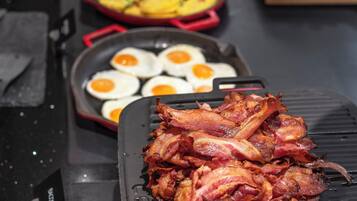 A buffet with various dishes including bacon, eggs, and vegetables.