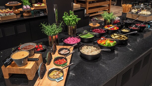 A buffet with various food items and a wooden counter. - Thon Hotel Brønnøysund (Brønnøy)