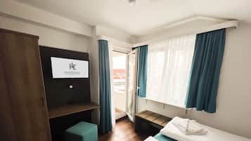 Une chambre d’hôtel avec un lit, un banc, une télévision et une vue sur l’extérieur.