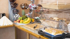 A buffet with various food items including fruits, pastries, and bread. - Hotel Hansa (Stuttgart)