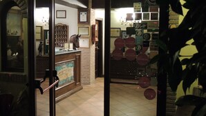 A reception area with a tiled floor, a reception desk, and a wall displaying various awards and plaques.