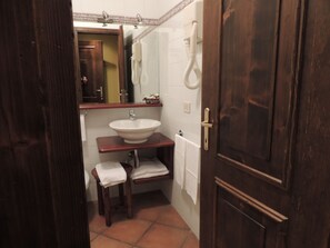 A small bathroom with a wooden vanity, a white sink, and a mirror. - Country Relais I Due Laghi (Anguillara Sabazia)