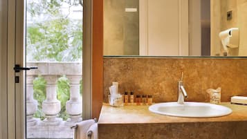 Une salle de bain avec un comptoir en marbre, un lavabo et une cabine de douche en verre.