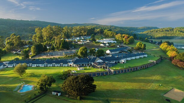 A large, well-maintained resort with multiple buildings, a swimming pool, and expansive green lawns. - Troutbeck Resort (Nyanga)