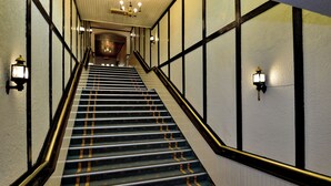Una escalera con barandilla e iluminación mural.