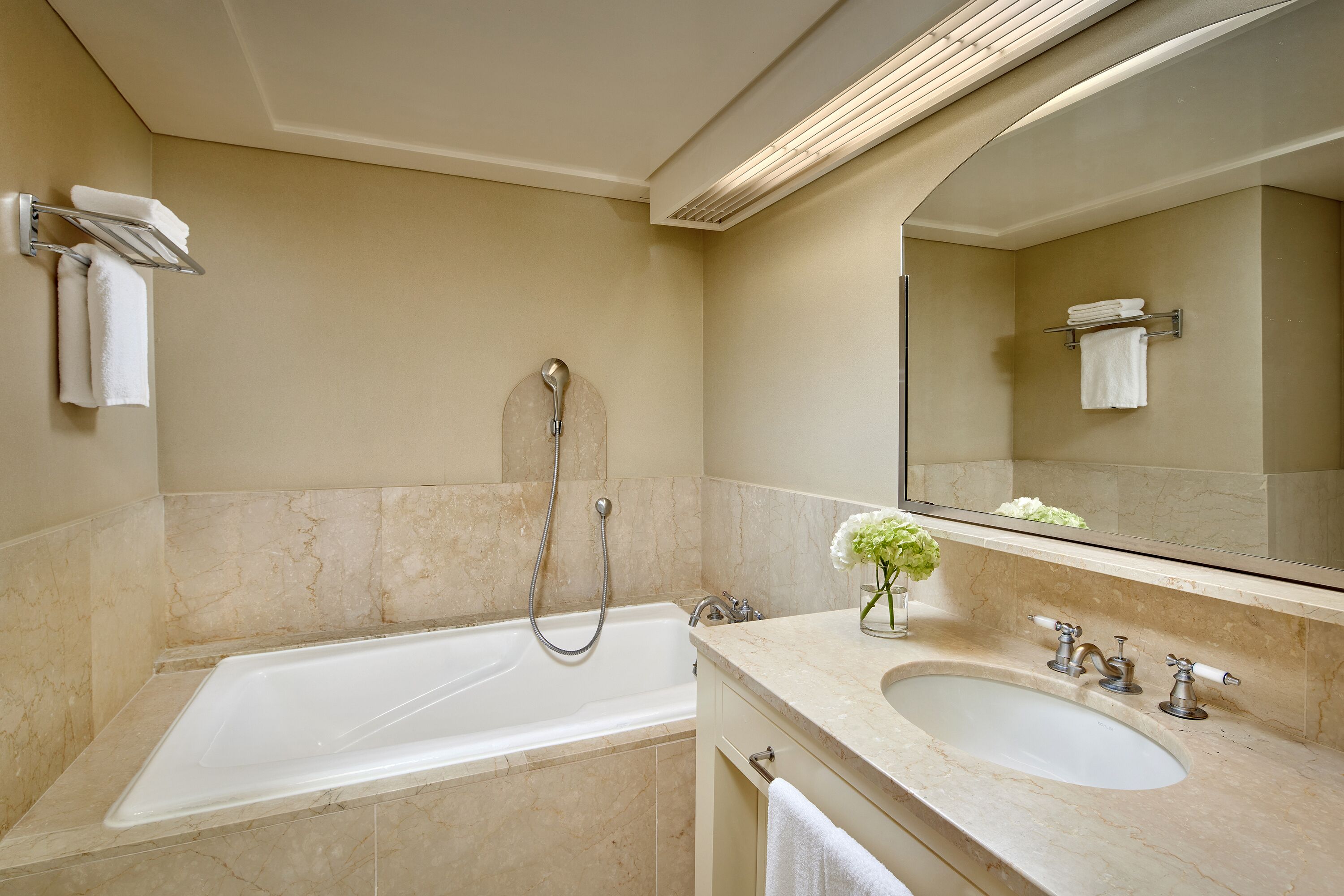 A modern bathroom with a bathtub, a sink, and a shower.