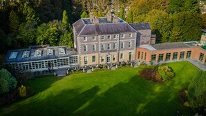 A large, multi-story building with a symmetrical facade, extensive windows, and a well-maintained lawn. - The Maryborough Hotel and Spa (Douglas)