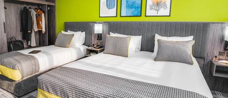 A hotel room with two beds, a wardrobe, and artwork on the wall.