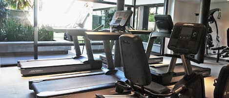 A gym with treadmills, an elliptical, and weight machines.