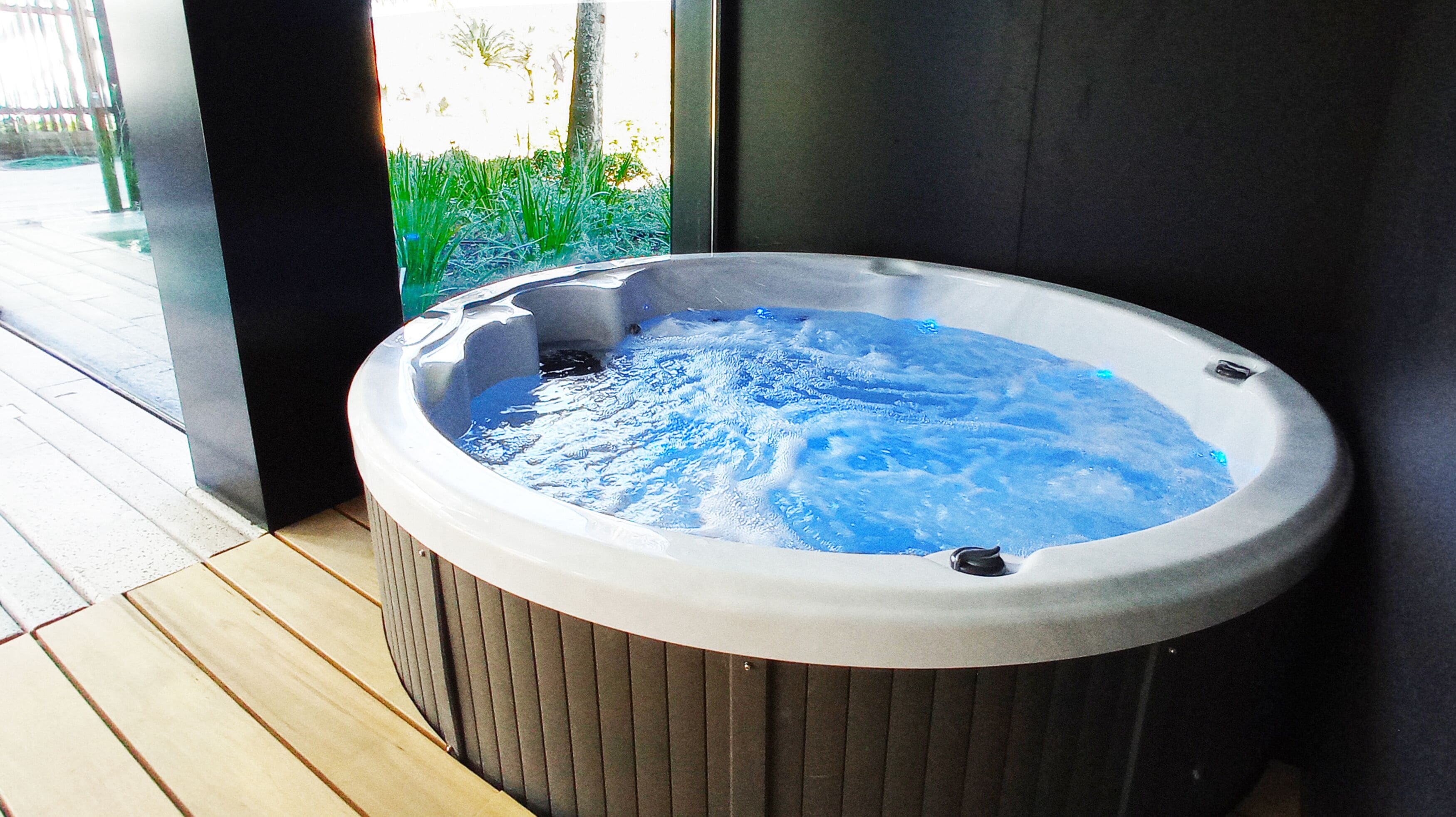 A hot tub with a view of greenery outside.