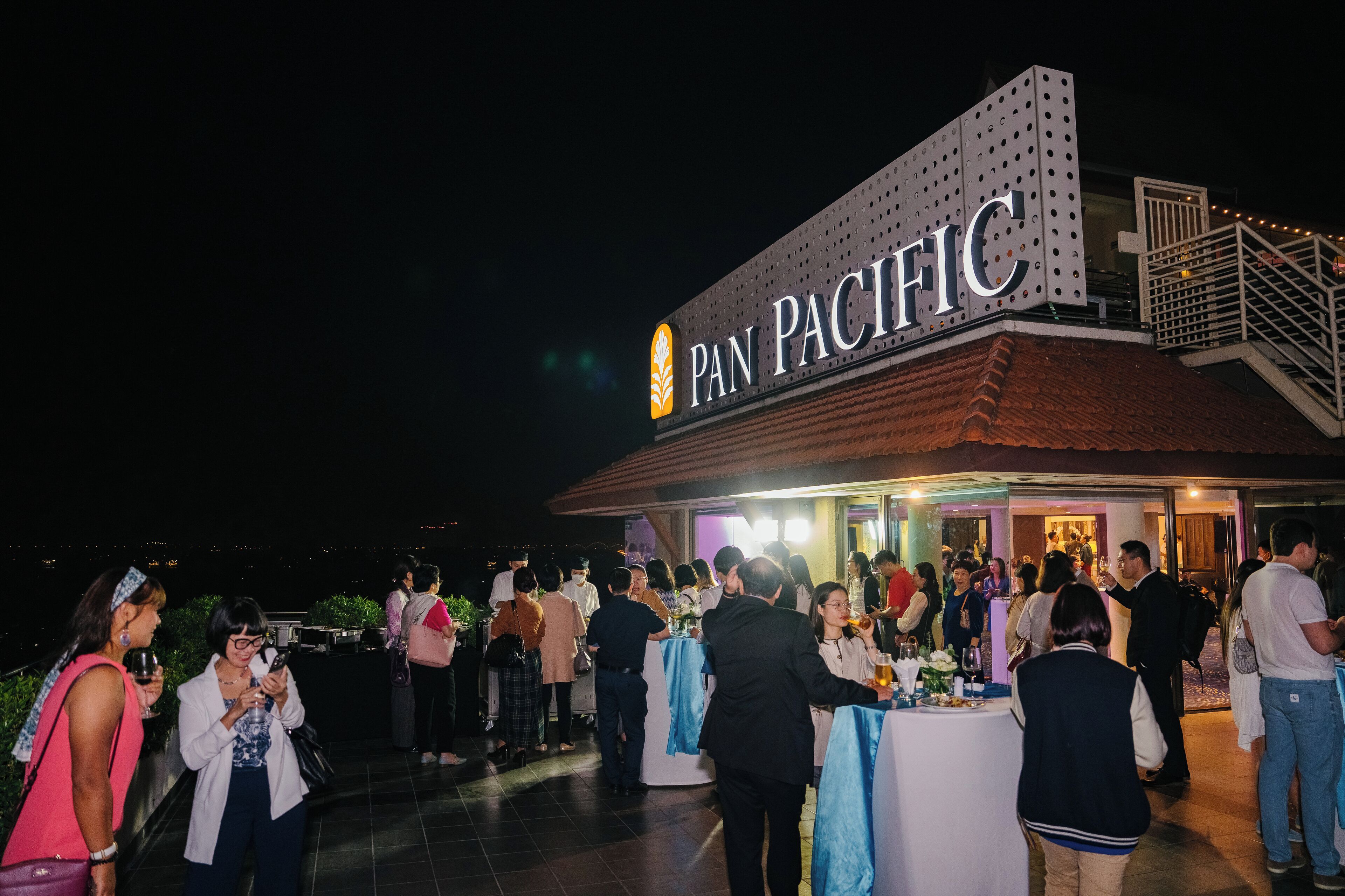 An outdoor event at a hotel with a sign reading "PAN PACIFIC".