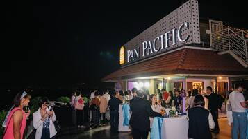 An outdoor event at a hotel with a sign reading "PAN PACIFIC".