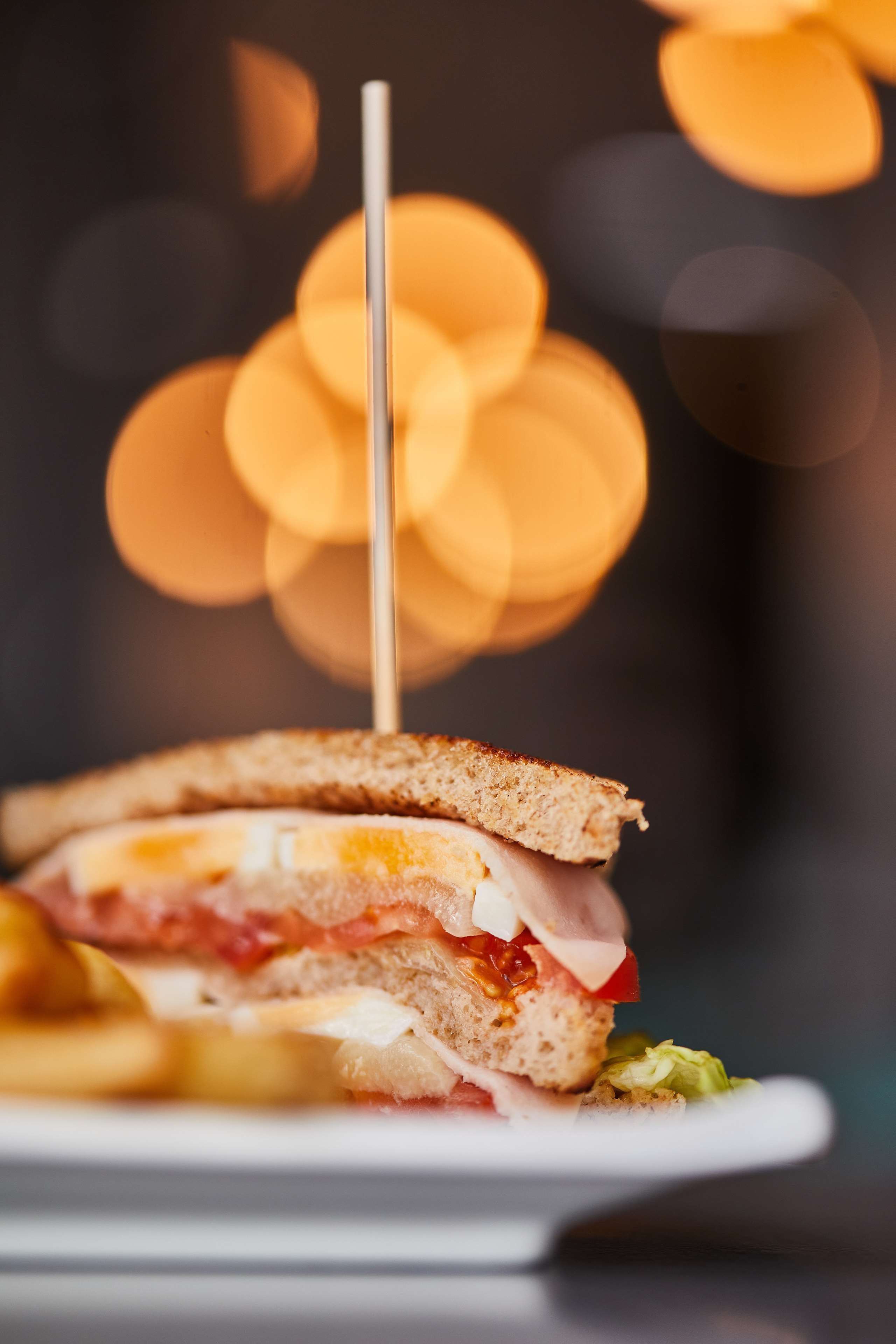 A sandwich on a plate with a toothpick.