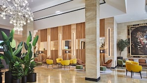 A modern lobby with a chandelier, seating area, and a large painting. - Hotel Silken Reino de Aragón (Zaragoza)