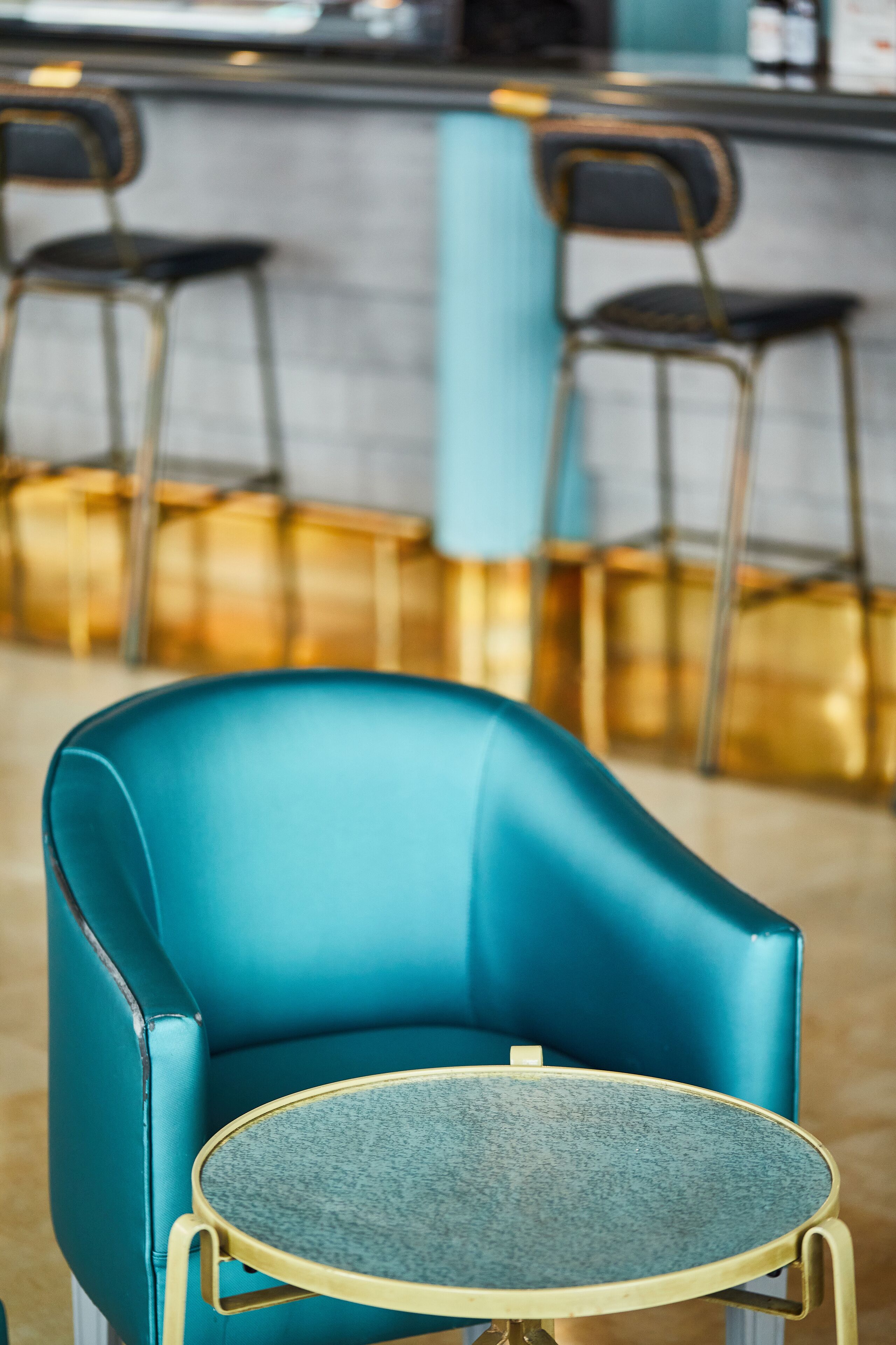 Een smaragdgroene stoel met een kleine ronde tafel in een modern interieur.