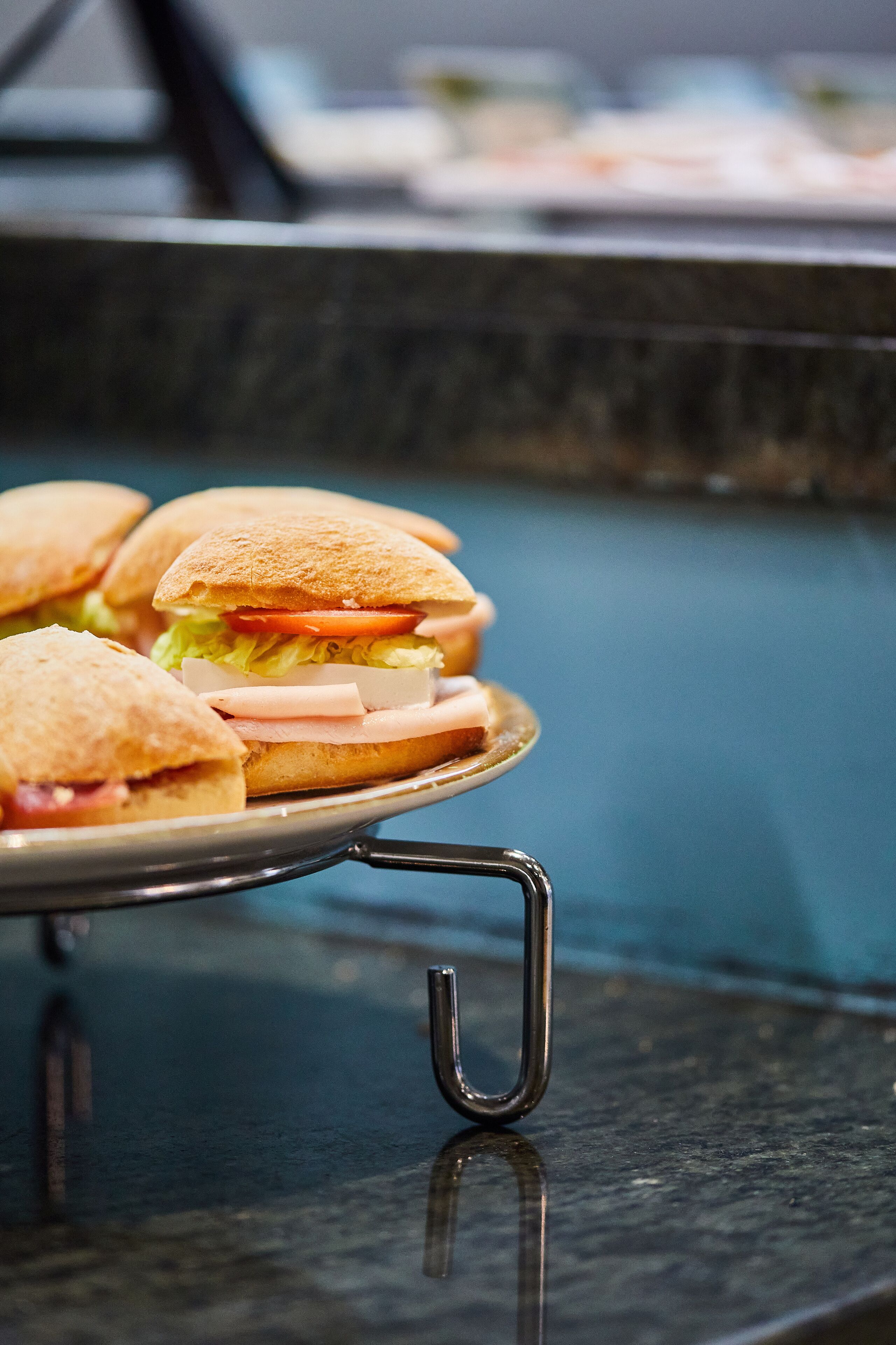 A tray of sandwiches on a reflective surface.