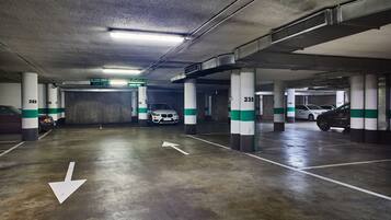 Un estacionamiento de varios niveles con espacios claramente delimitados y flechas direccionales en el suelo.