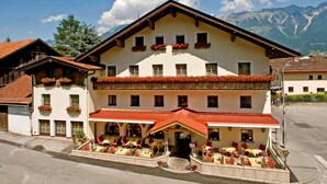 A hotel with a red roof, multiple windows, and flower boxes on the balconies. - Hotel Bierwirt (Innsbruck)