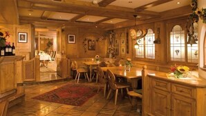A wooden interior with a dining area, kitchen, and a staircase. - Hotel Bierwirt (Innsbruck)