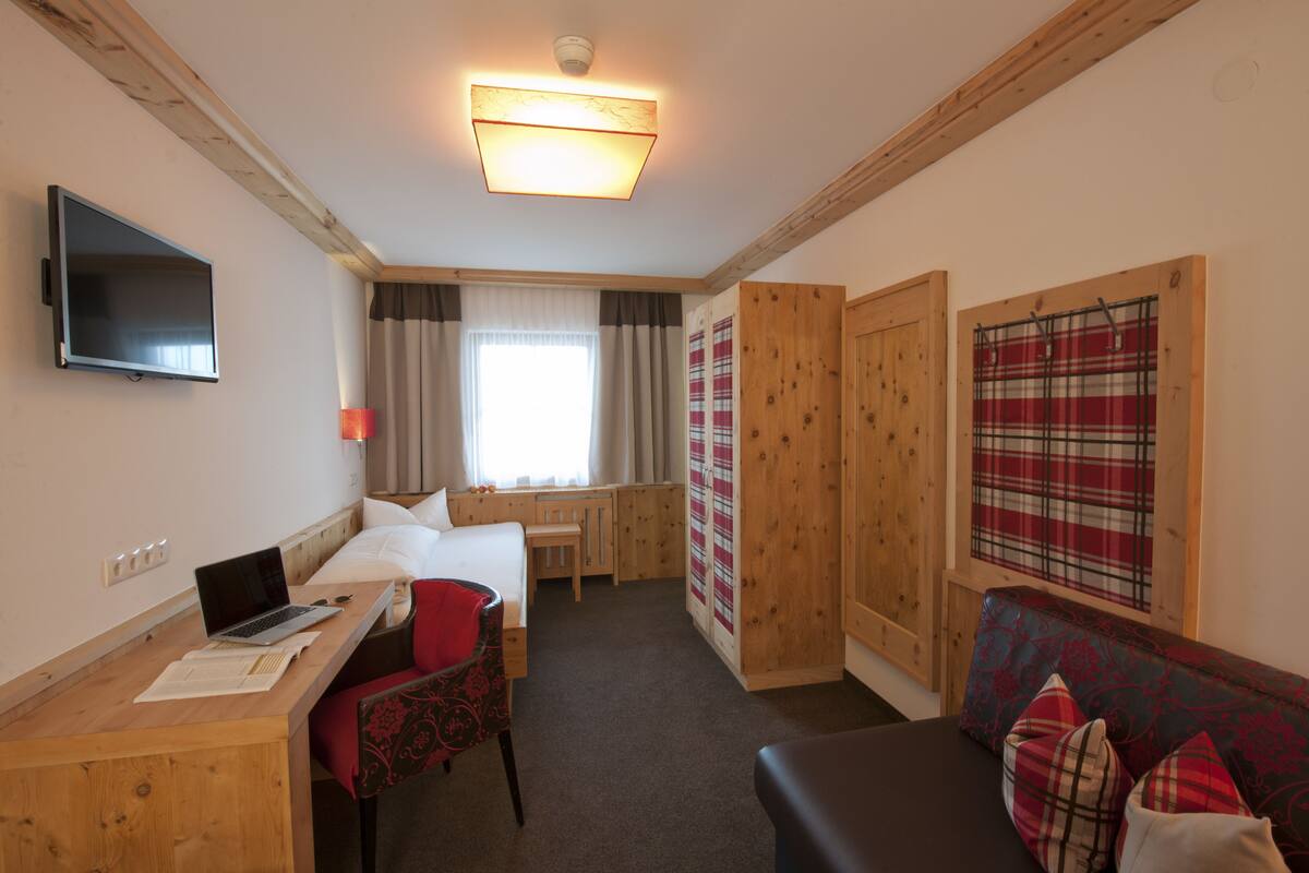 Une chambre d’hôtel avec un lit, un bureau, une chaise et un canapé.