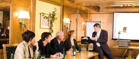 A conference room with wooden paneling, a whiteboard, and a projector screen.