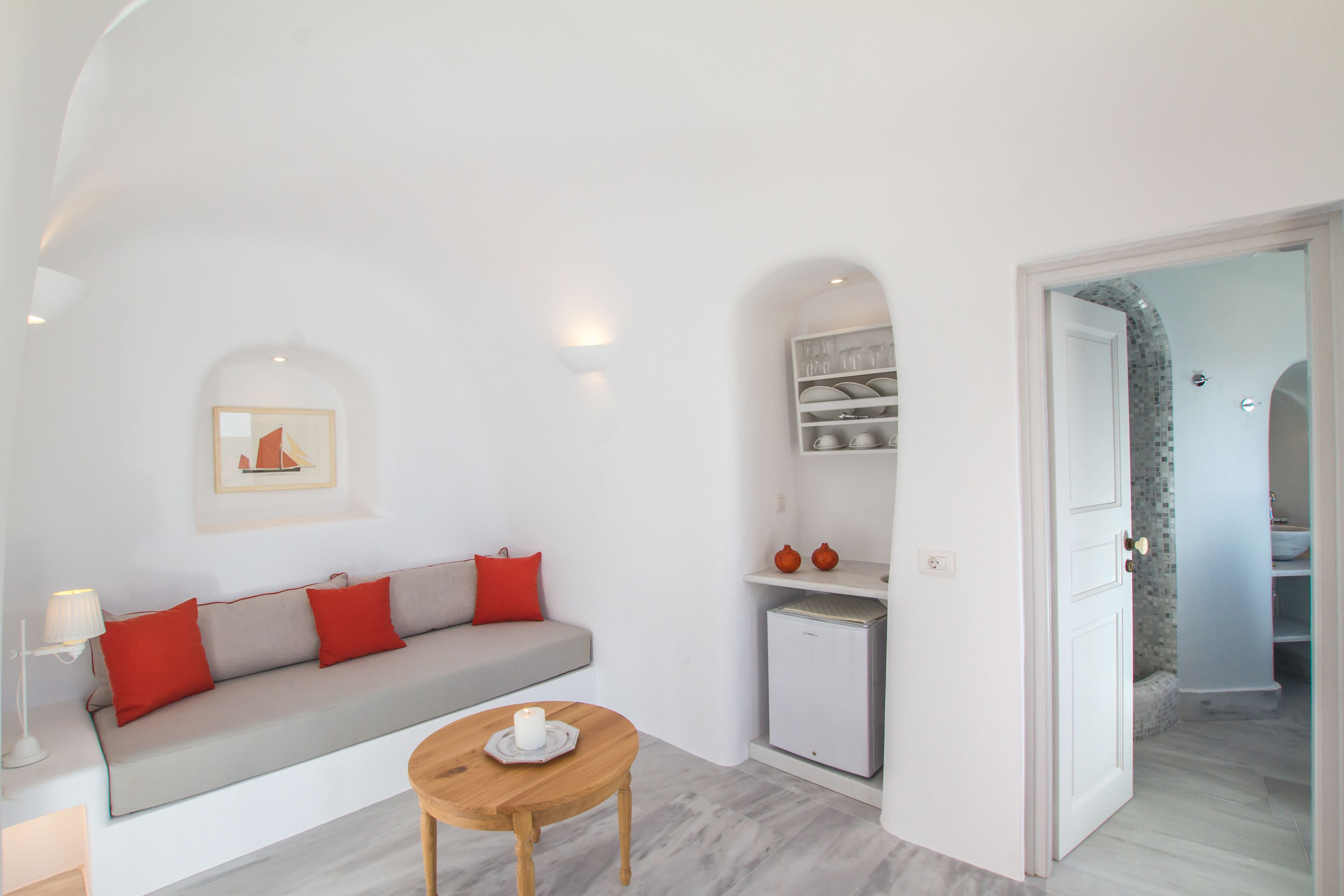 Una sala de estar moderna con un sofá, una mesita y un refrigerador.