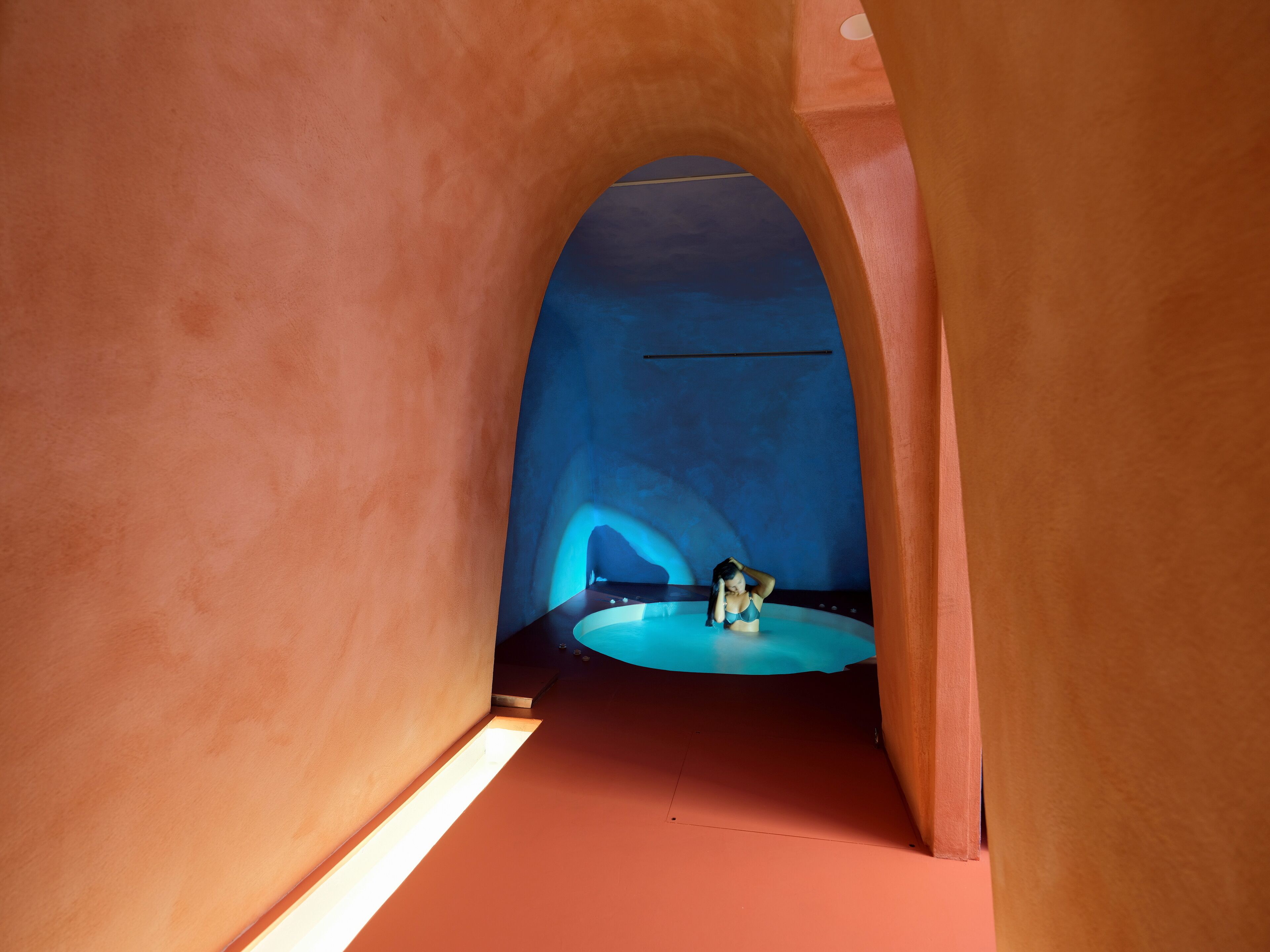 A narrow hallway with arched ceilings and a central circular platform.